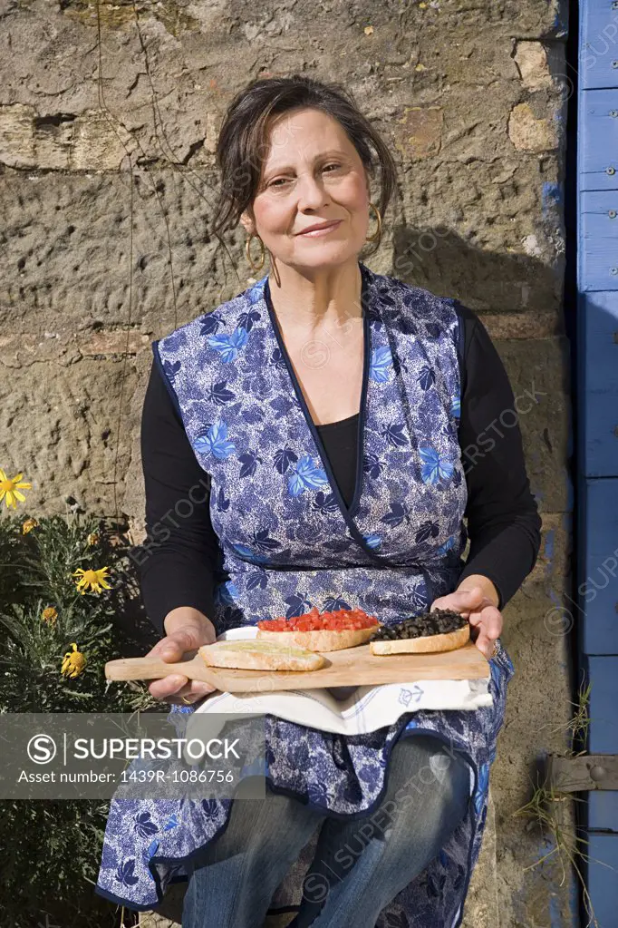Mature woman holding slices of bruschetta