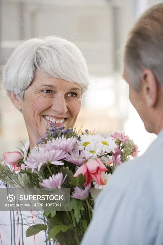 A senior man giving a senior woman flowers