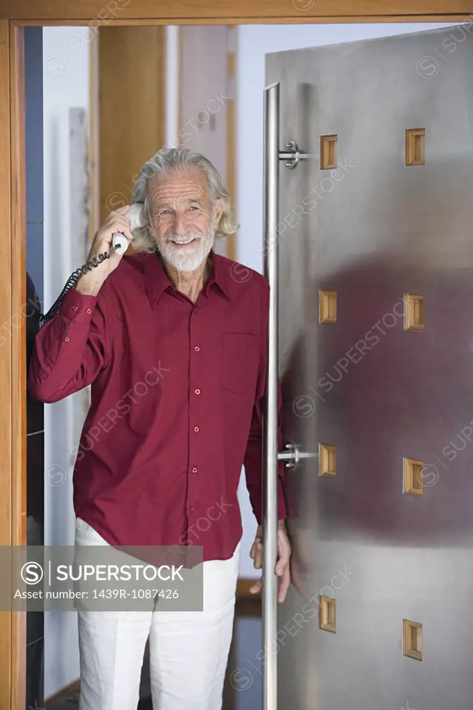 Man with telephone by door