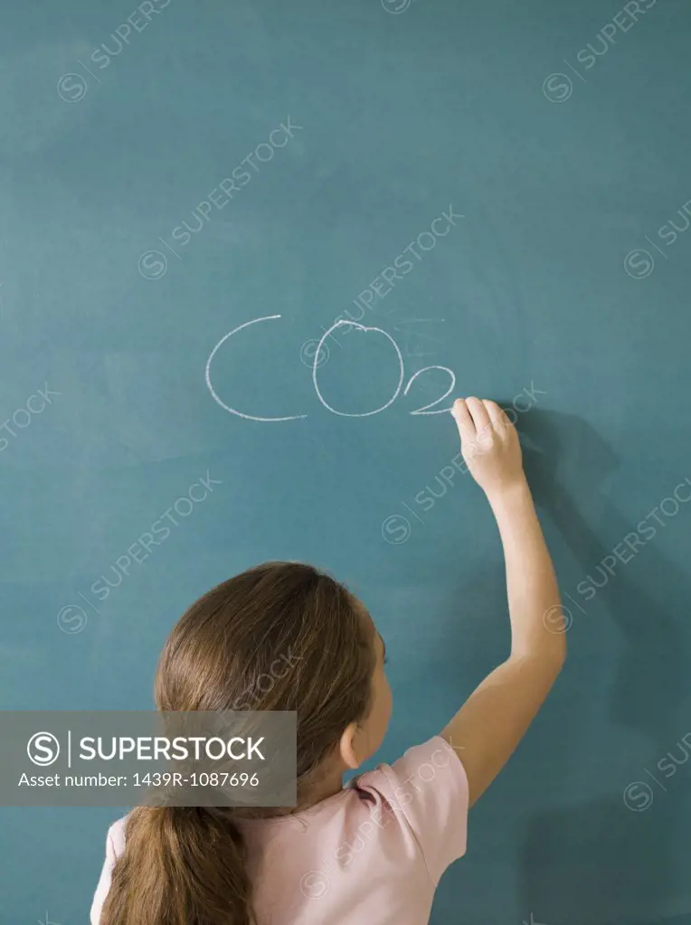 Girl writing on a blackboard