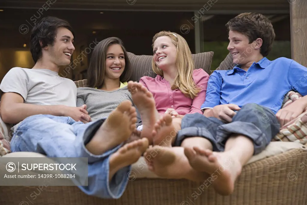Teenagers sat on a sofa talking