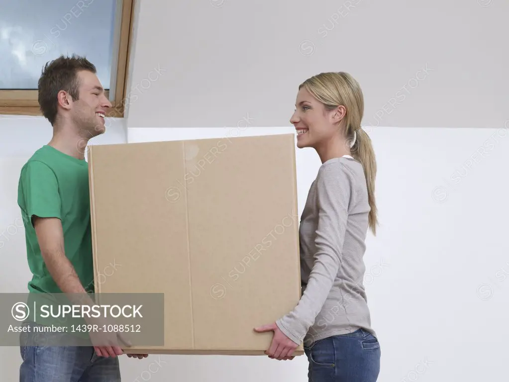 A couple carrying a cardboard box