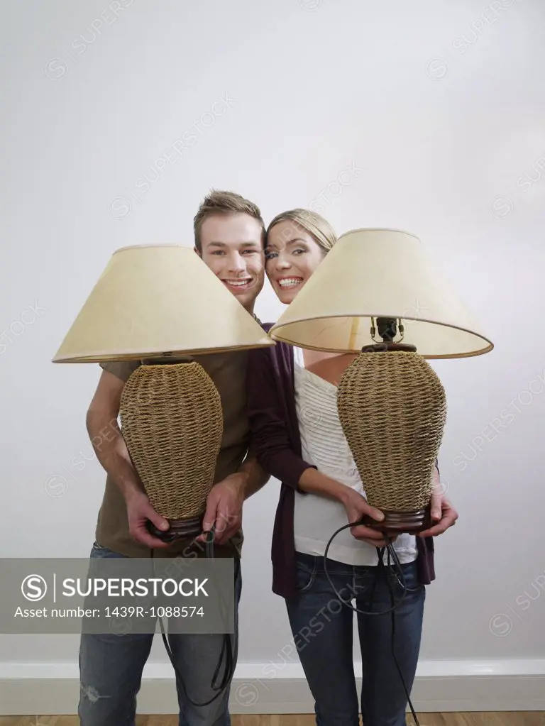 Portrait of a couple holding lamps
