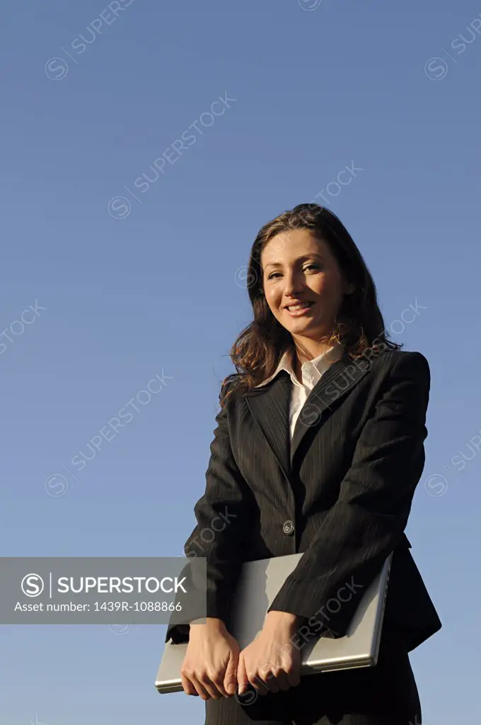 Businesswoman outdoors with laptop