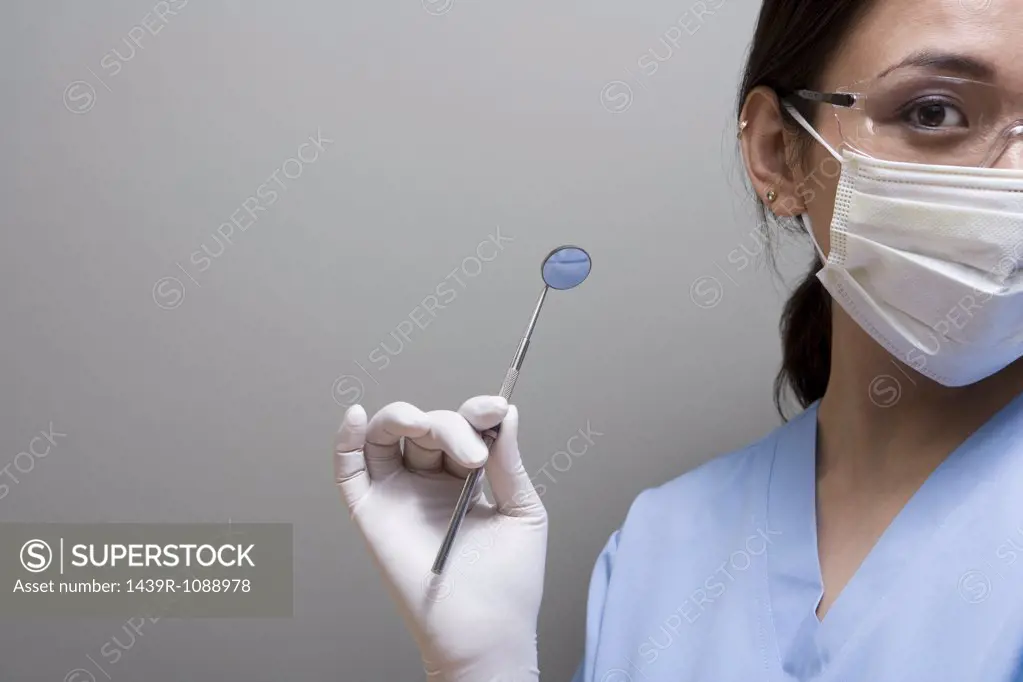 A dentist holding a piece of dental equipment