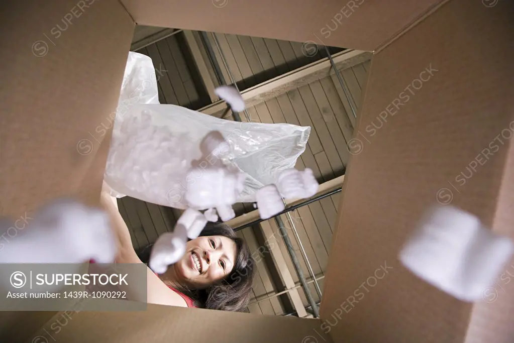 Woman putting packing peanuts in box