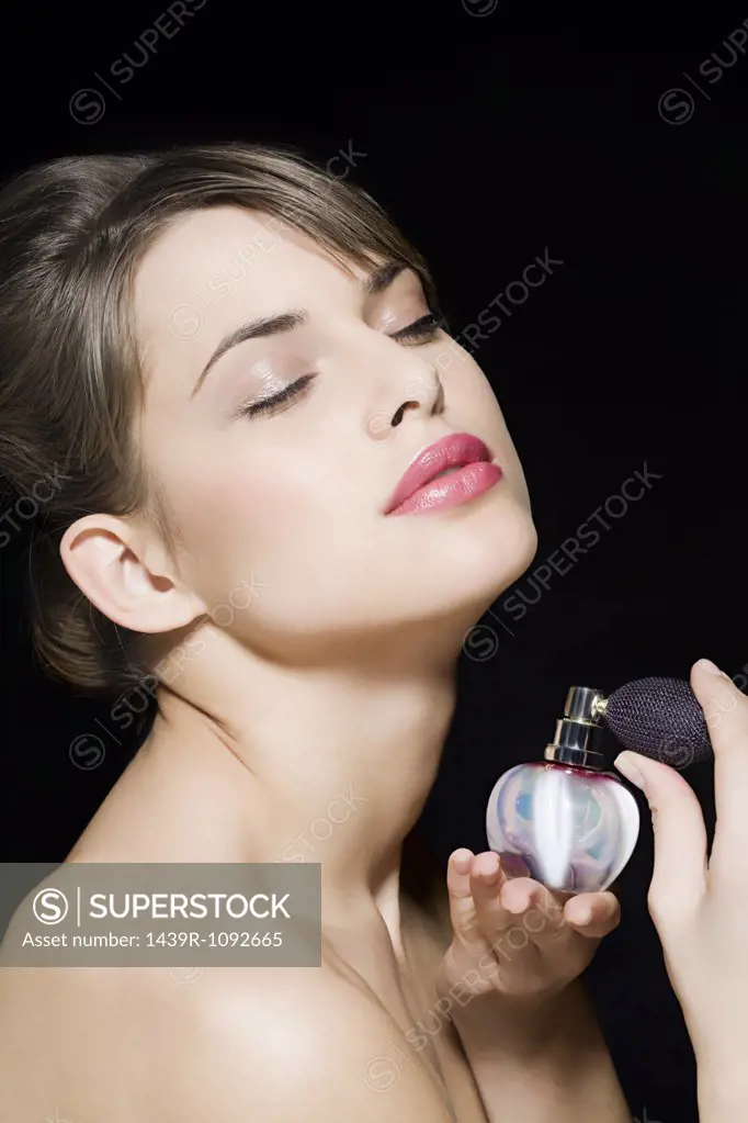 Woman spraying perfume