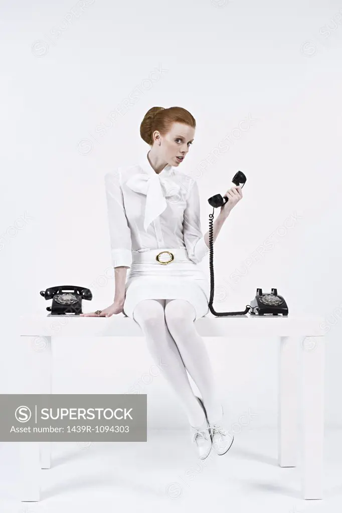 A businesswoman holding a telephone