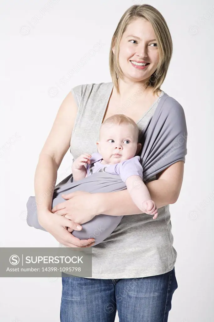 A mother carrying her baby in a sling