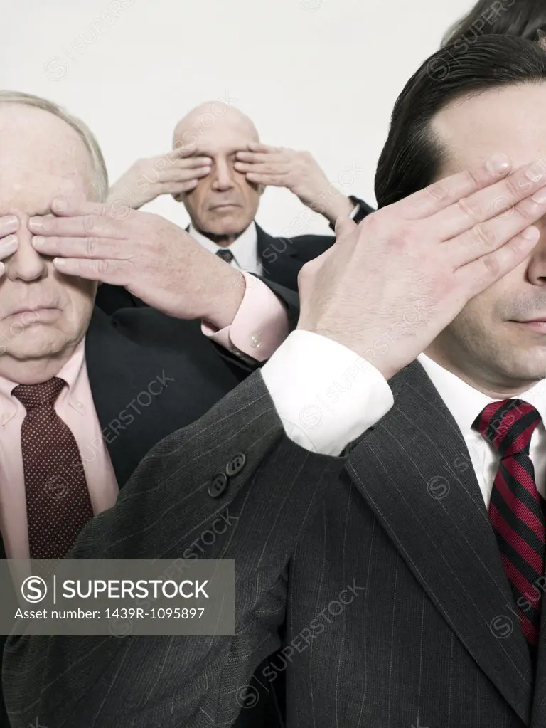 Businessmen covering eyes
