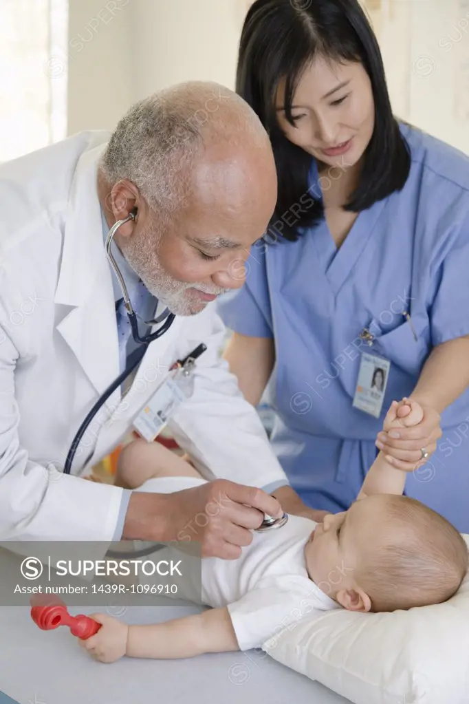 A doctor and nurse examining a baby