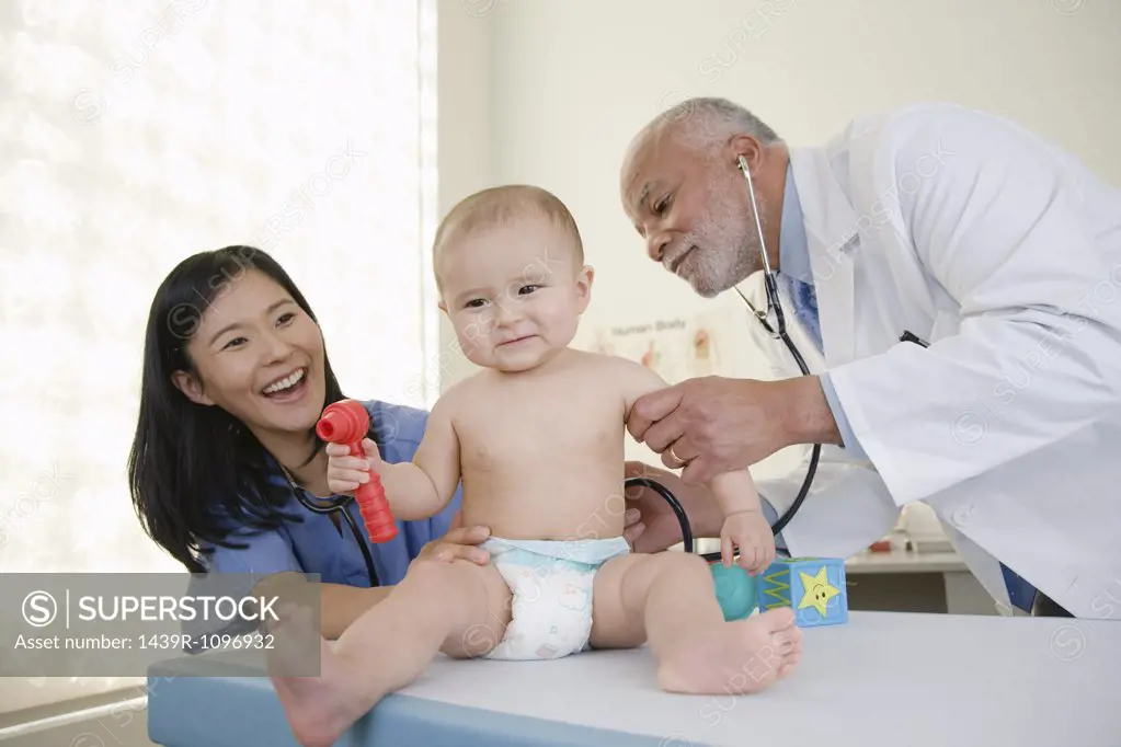 A doctor and nurse examining a baby