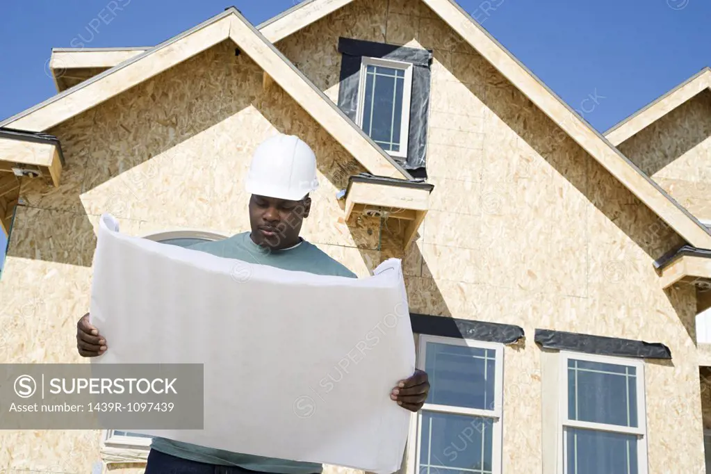 A builder holding a blueprint