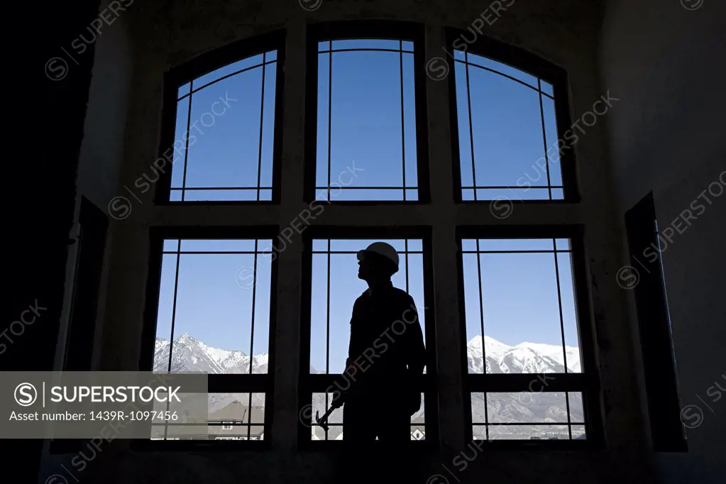 Silhouette of a builder against a window