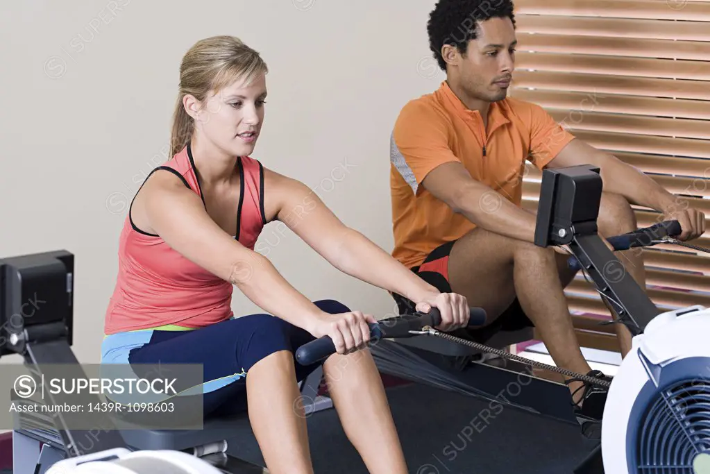 Woman and man on rowing machines