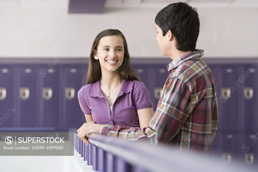 Teenage boy and girl talking in a corridor