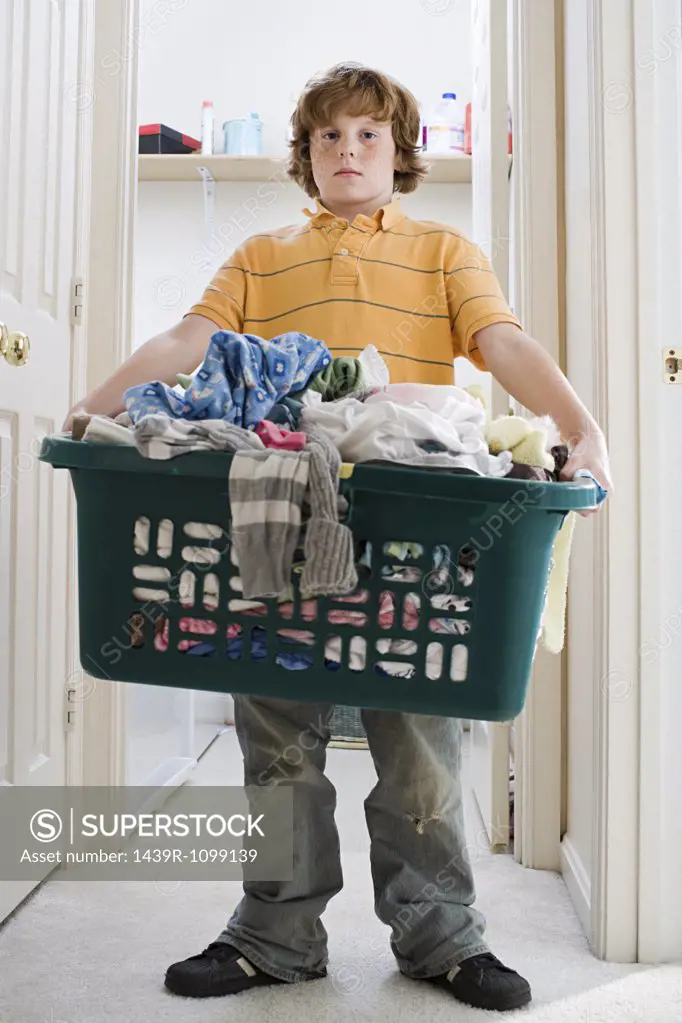 A boy carrying a laundry basket
