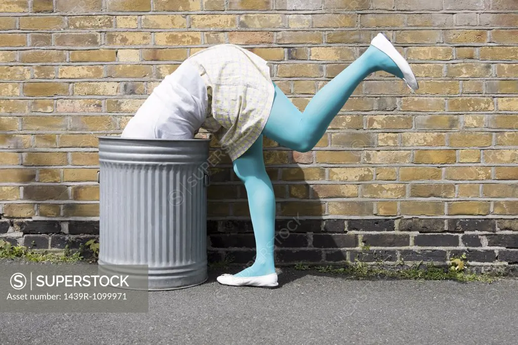 Woman looking in a dustbin