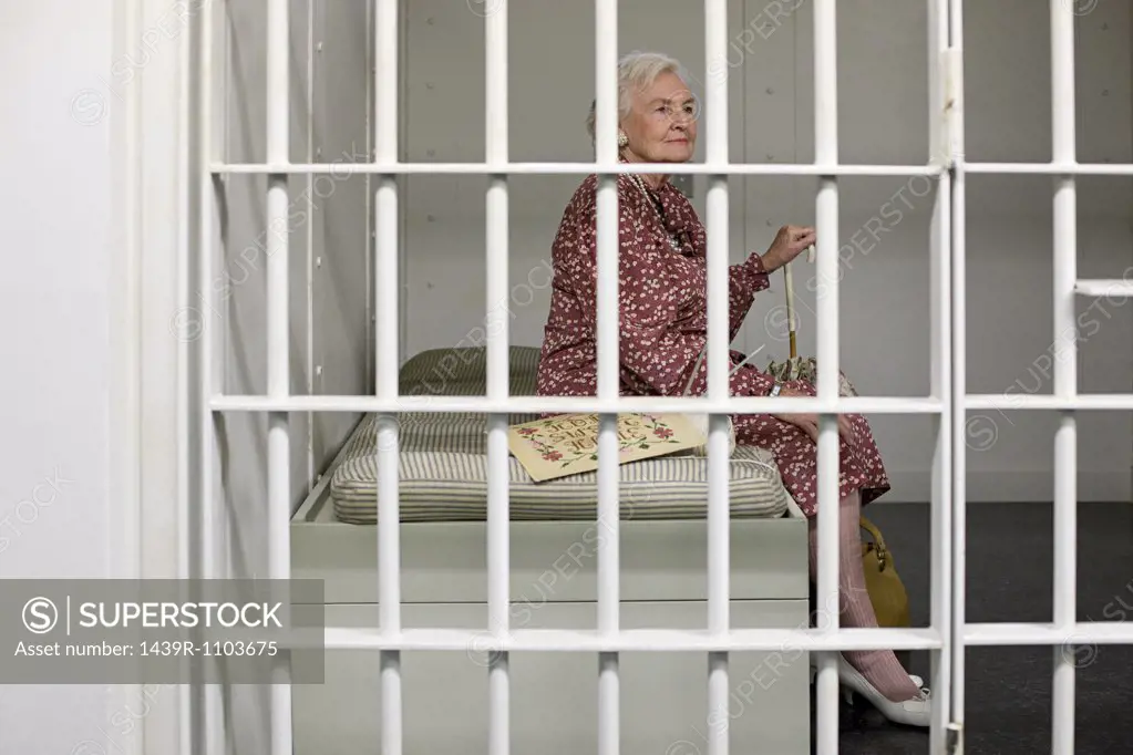 Senior woman in prison cell