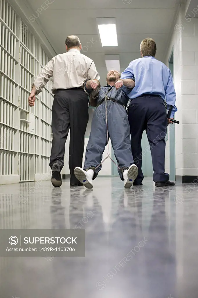 Prisoner being dragged down corridor