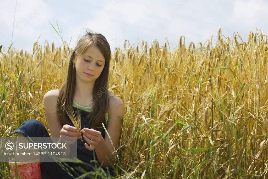 A girl sitting in a corn field