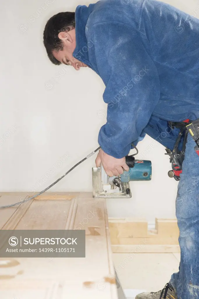 A carpenter using a sander