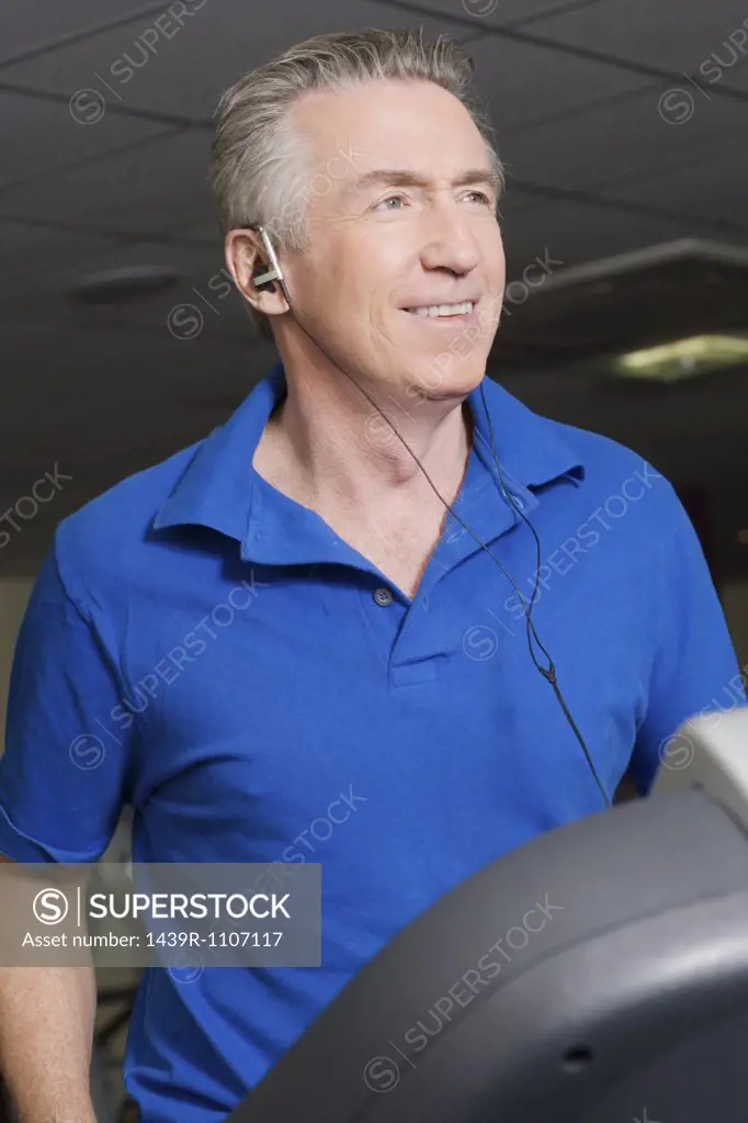 A mature man listening to music whilst exercising