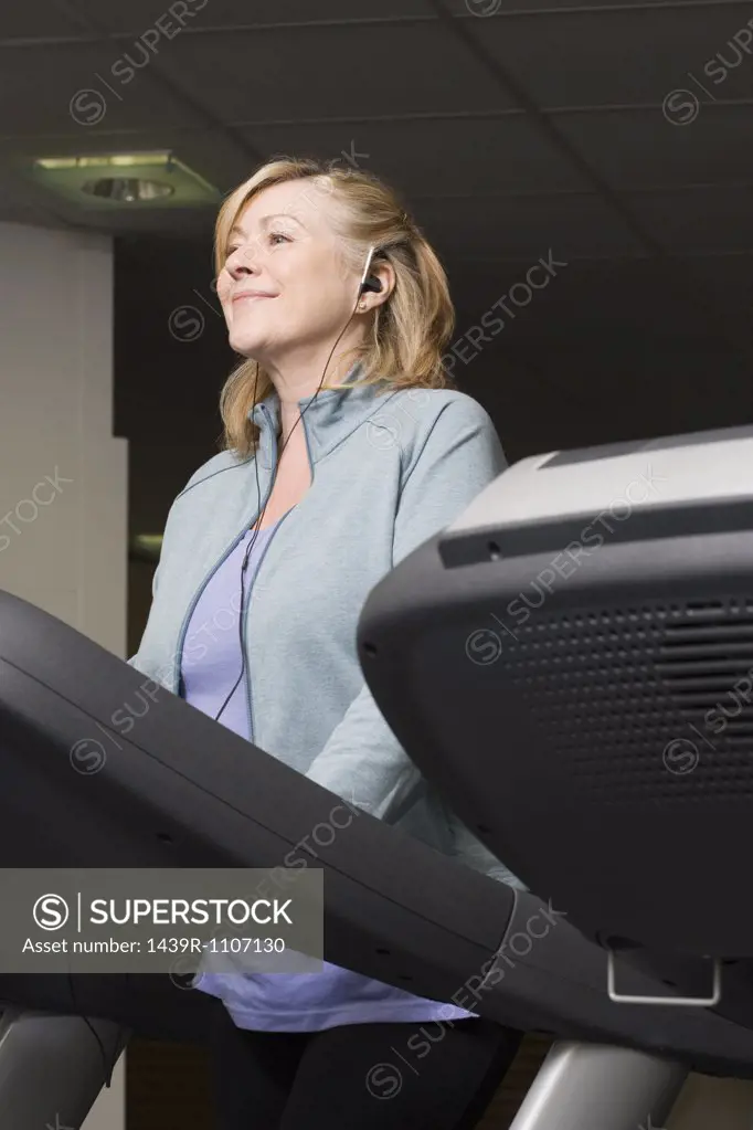 A mature woman listening to music whilst exercising