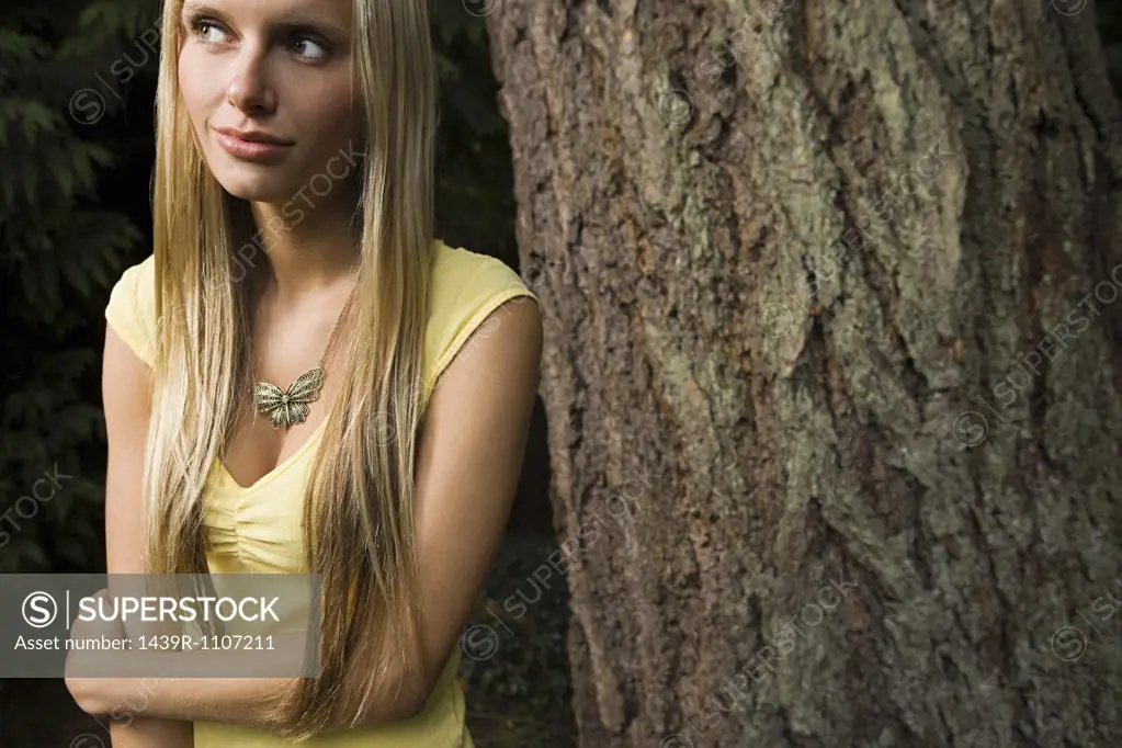 Young woman by tree