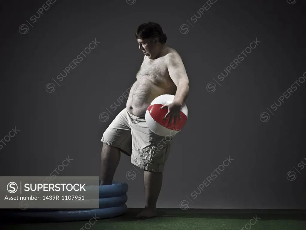 Man with beach ball and paddling pool