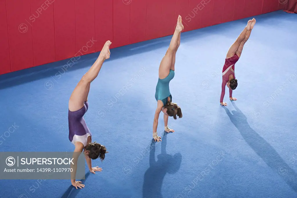 Gymnasts in a row doing handstands