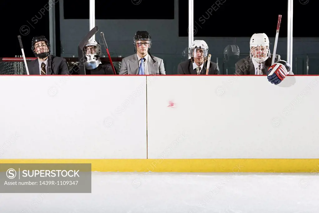 Businessmen playing ice hockey