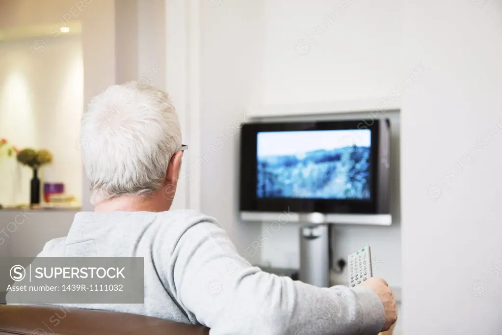 Mature man watching television