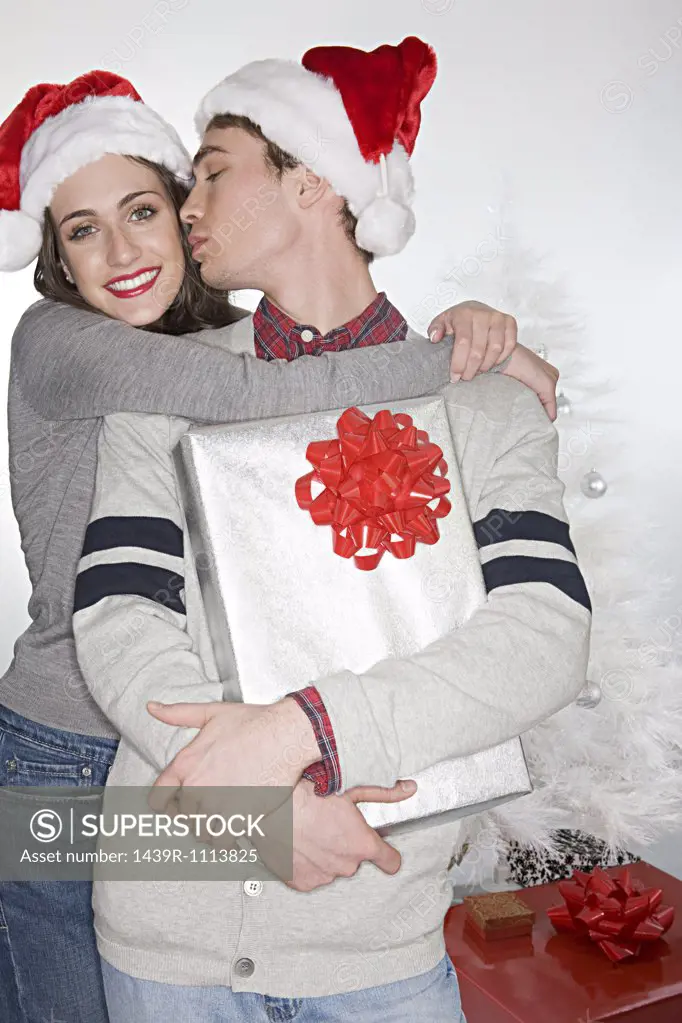 Couple in santa hats kissing