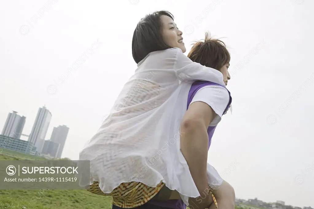 Young man giving girlfriend piggyback