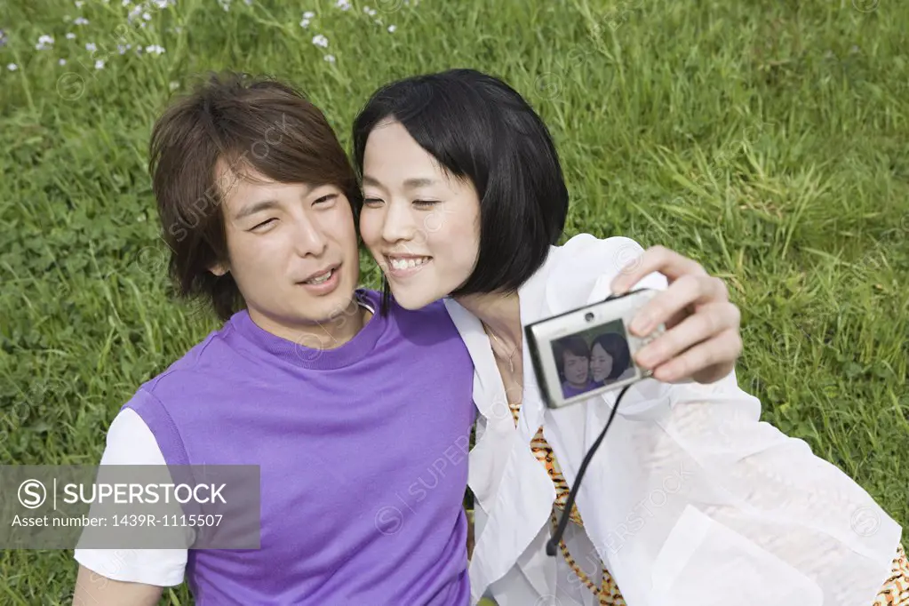 Young couple on field with camera