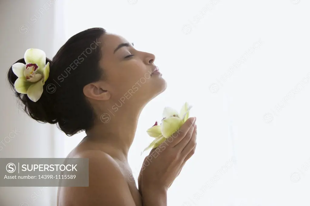 Young woman holding an orchid flower