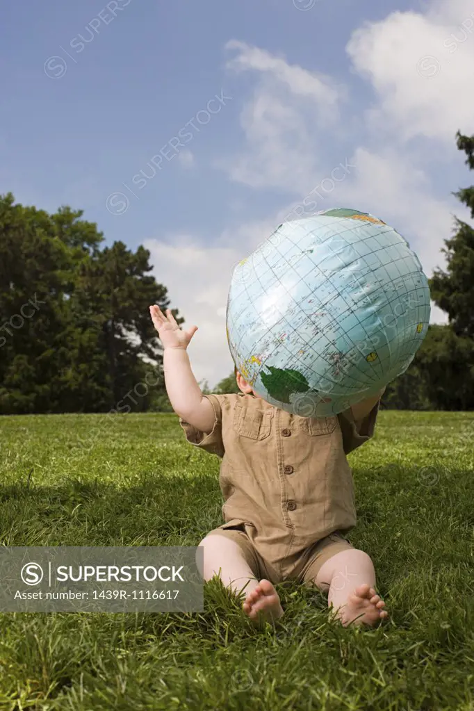Baby in park with inflatable globe