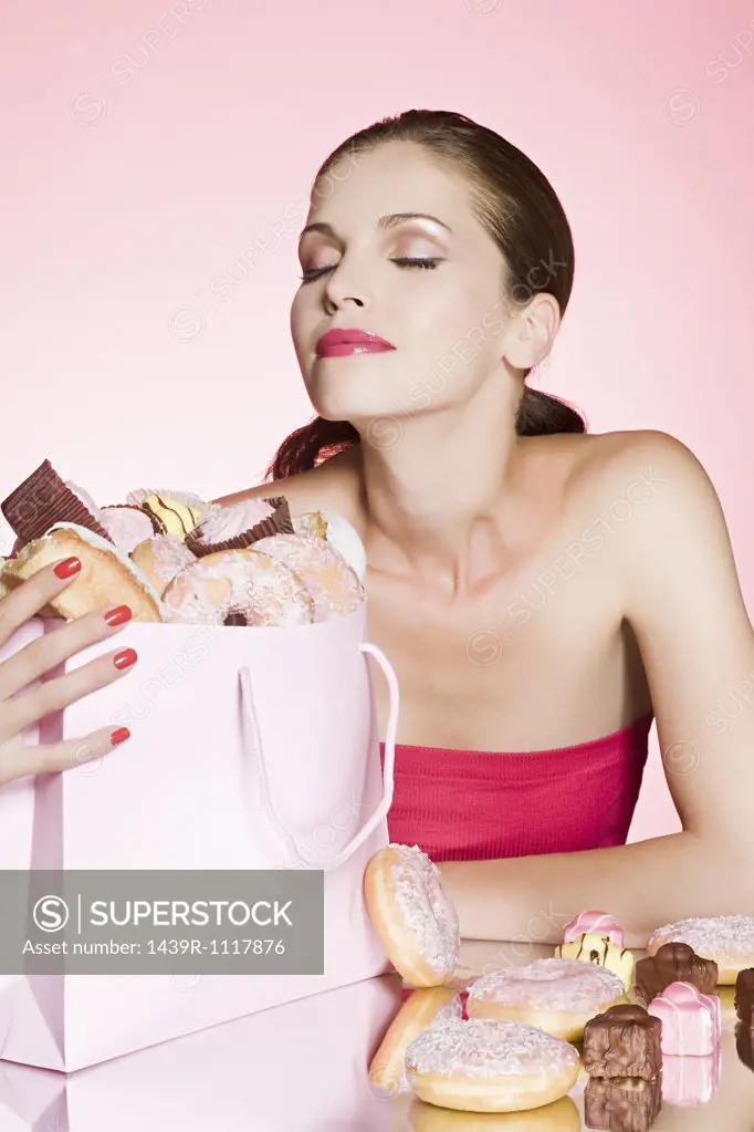 Young woman with bag of cakes and donuts