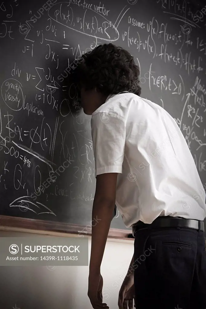 Boy leaning on blackboard