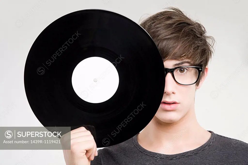 A teenage boy holding a vinyl record