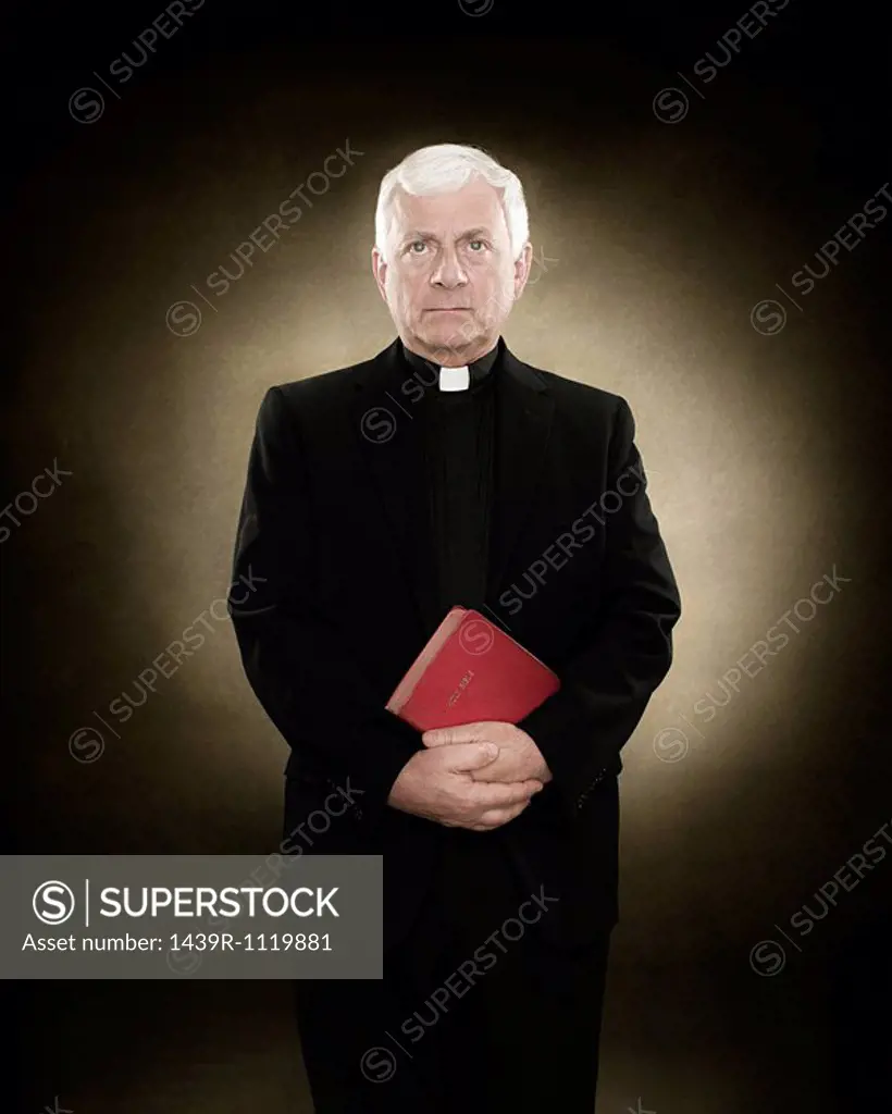 Portrait of a priest holding a bible