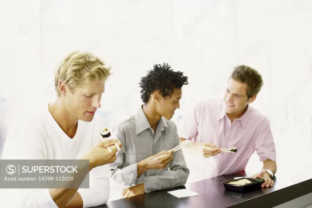 Men eating at sushi bar
