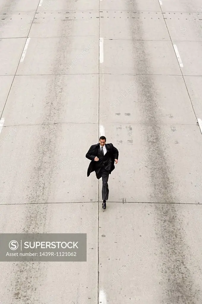 Looking down to a businessman running down a road