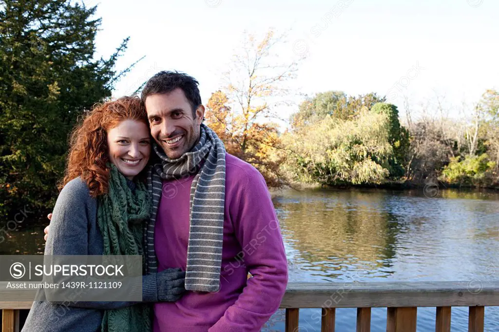 Portrait of a happy couple on a river bridge