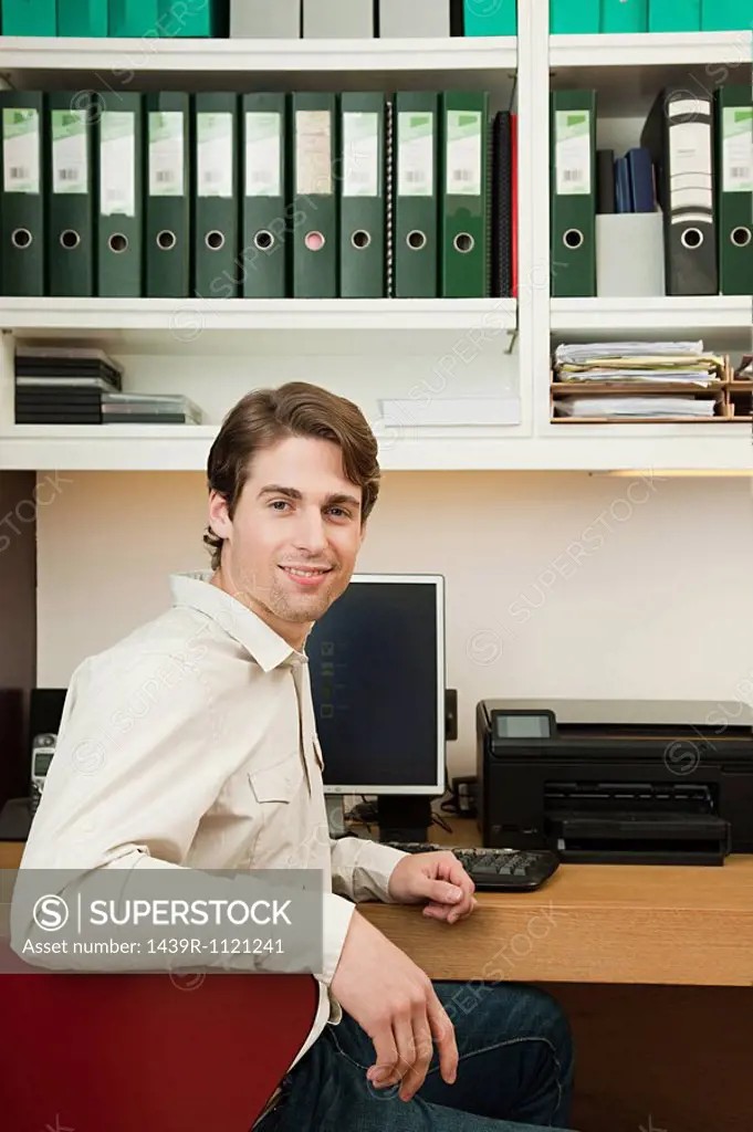 Young man sitting in home office