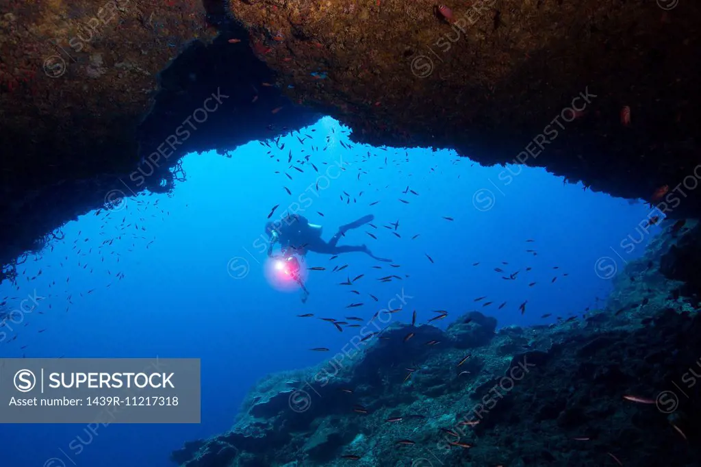 Diver framed by cavern.