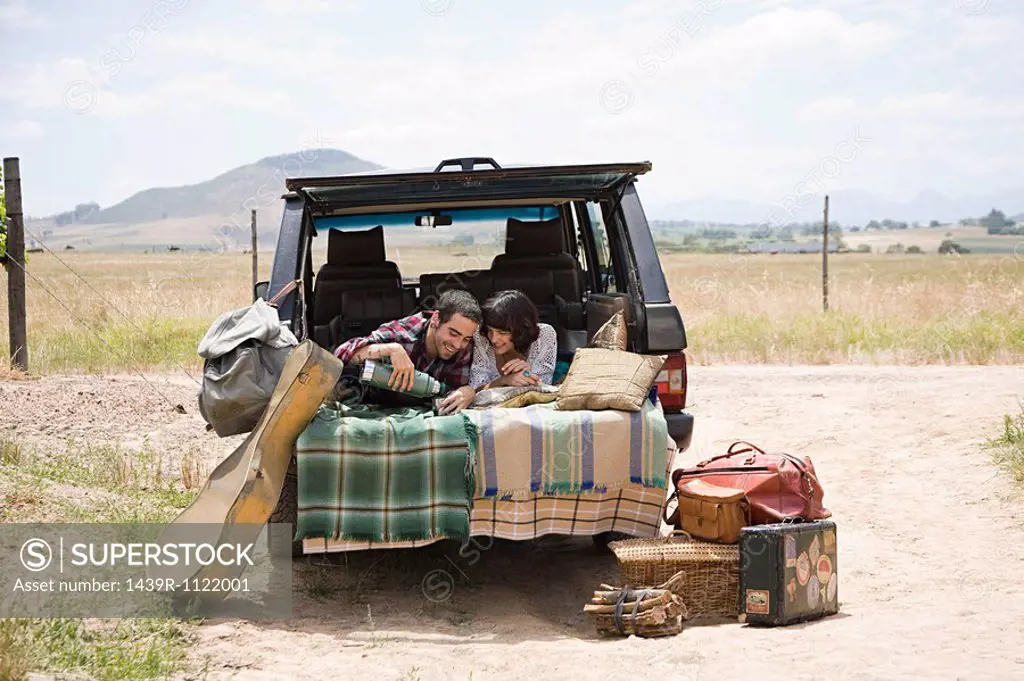 Couple relaxing in back of suv