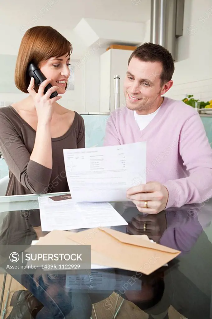 Couple on telephone with bills
