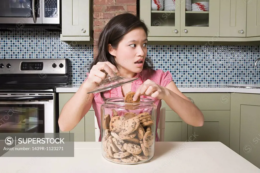 Young woman with cookie jar